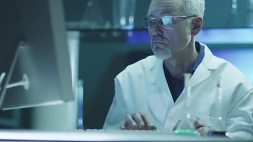 Scientist Typing at Computer in Medical Research Lab
