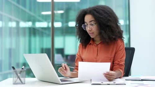 Joyful young african american businesswoman is satisfied with results of a financial report
