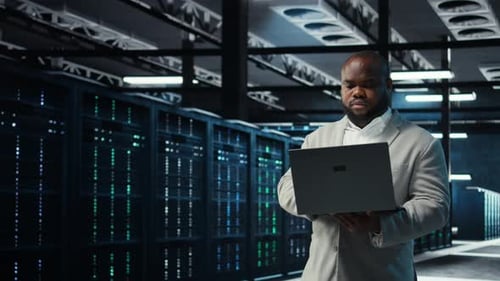 Man Holding Laptop in Data Center Server Room