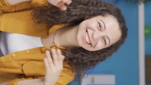 Smiling Young Woman Waving and Clapping