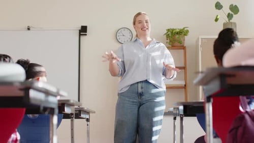Teaching in classroom, female teacher engaging with students during school lesson