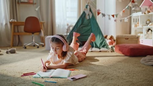 Girl Lying on Floor Drawing in Bedroom