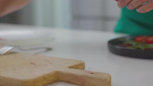 Adult Preparing Fresh Salad in Bright Kitchen
