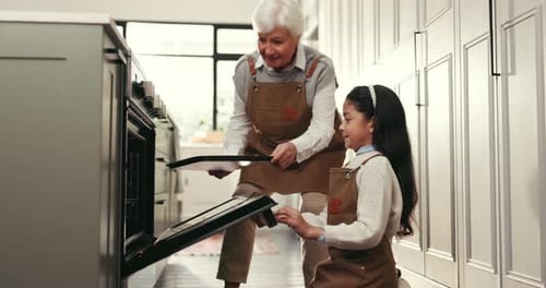 Grandmother and Granddaughter Baking Together in Kitchen