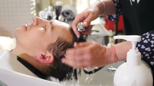 Man Getting Hair Washed at Salon Sink