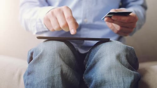 Man Using Tablet with Credit Card Indoors
