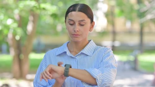 Woman Uses Smart Watch Outside in Daytime