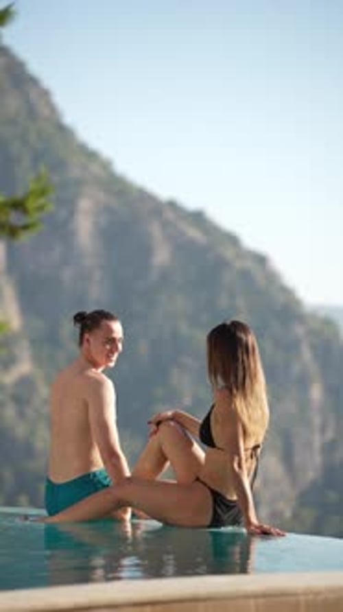 Couple enjoying infinity pool during luxury holiday