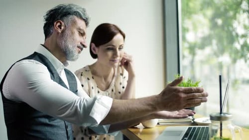 Mann und Frau bei Geschäftstreffen in einem Café mit Laptop
