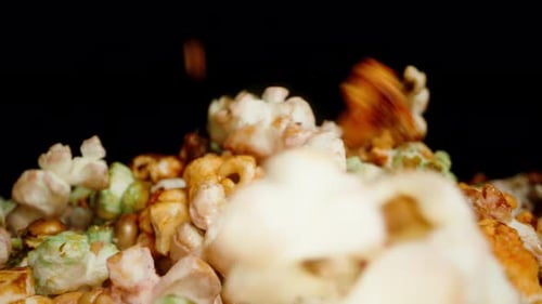 A mountain of sweet colorful popcorn forms from falling from above. Slow motion. Slider.