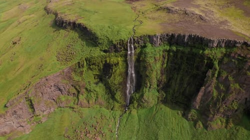 Incredible Iceland Waterfall Aerial Circles Lush Green Mountain Landscape. Water Gently Cascades