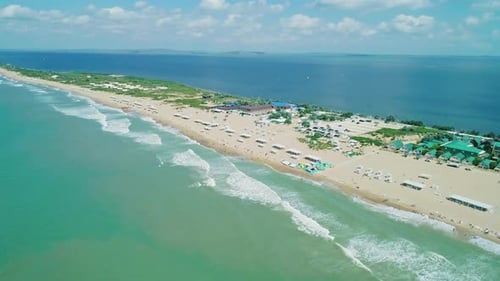 Aerial Over the Long Sandy Spit with a Beach and Azure Water on a Sunny Summer Day Waves Crashing to