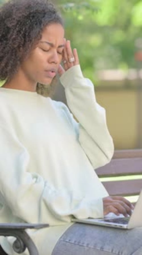 Tired Woman With Laptop Rubbing Temple Outdoors