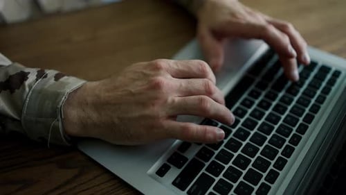 Hands of a Male Military in Uniform Typing Notes Laptop Work