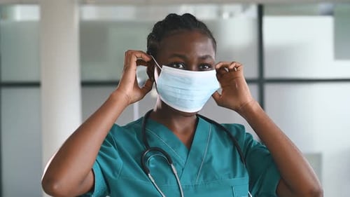 Young Woman Medical Professional Putting on Protective Mask