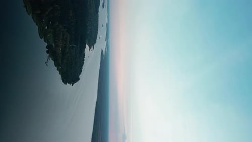 the Camera Flies High Over a Wide River During Sunrise Along the Riverbed