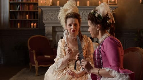 Women in historical costumes socializing in an elegant room