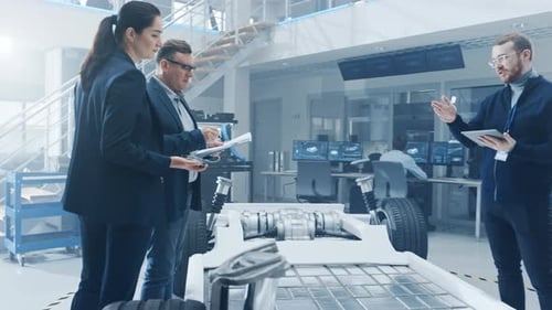 Engineers Reviewing Vehicle Chassis Design in Modern Lab