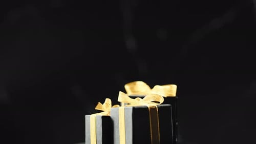 Elegant Black Gift Boxes with Gold Ribbons Rotating