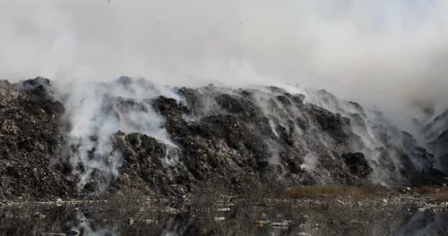 Close up of landfill with burning trash piles