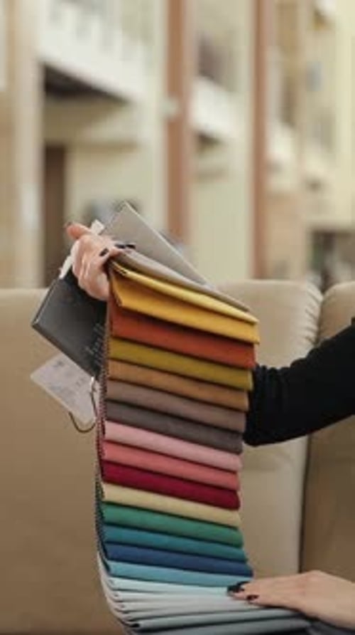 Vertical Video Woman in a Store Chooses the Color of Fabric for Bed Linen