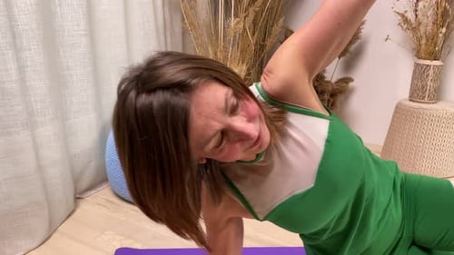 Eine aktive ältere Yogi führt im Apartmentstudio die Side Plank-Pose auf