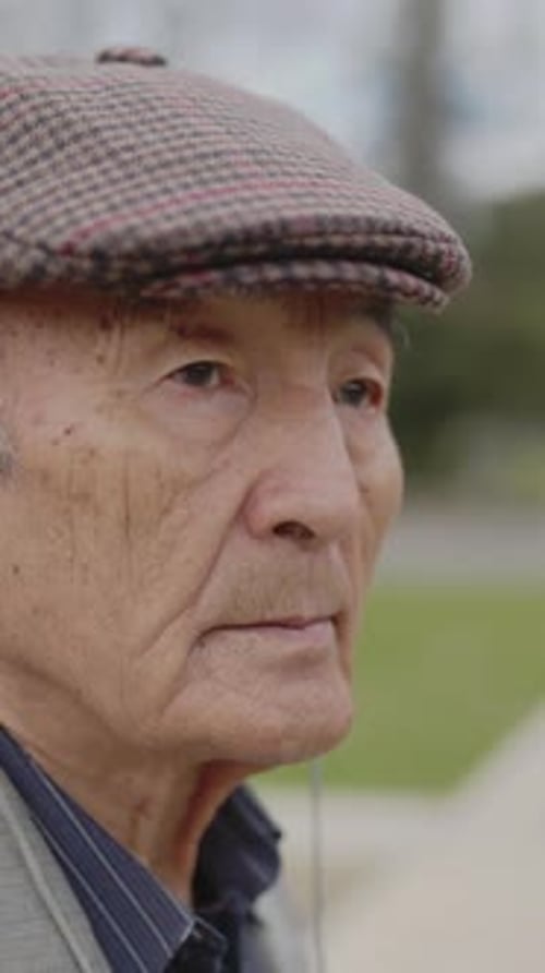 Senior Man Wearing Cap Outside Looks thoughtful