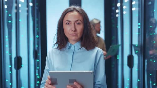 A Focused Woman Working in a HighTech Environment Surrounded By Data Center Equipment