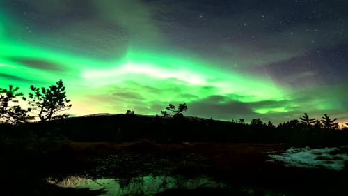 Geomagnetic storm with green aurora borealis in night sky, Finnsnes. Time lapse