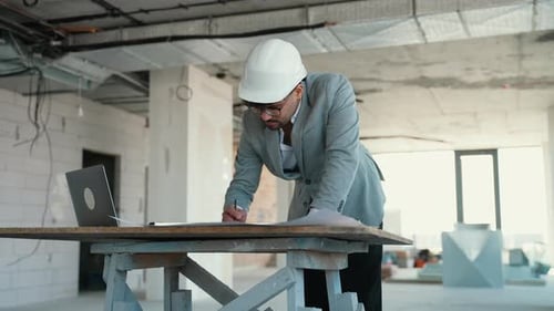 Architect Reviewing Blueprints on Construction Site and Having a Video Call