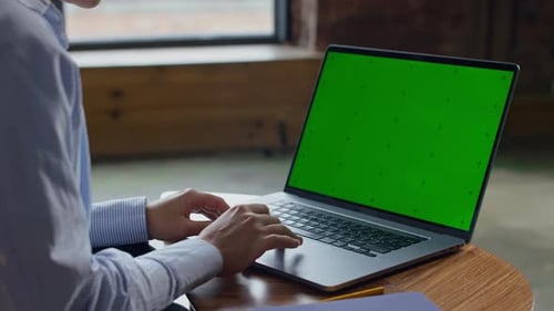 Person Browsing on Laptop with Green Screen