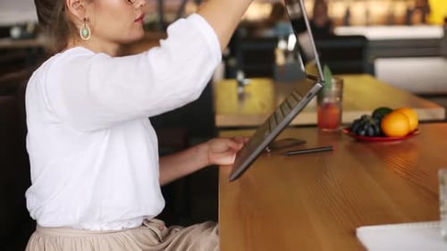 Mixed Race Freelancer Transforms Convertible Laptop Into Tablet While Working in Cafe Asian