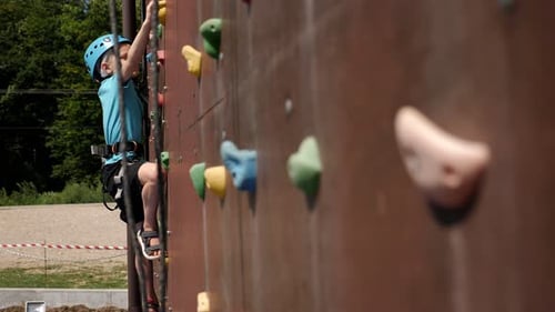 Boy Climbing Rock Wall Wearing Safety Helmet