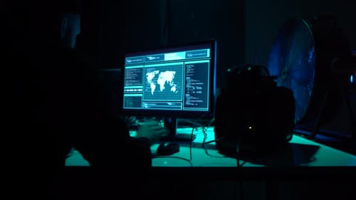 Man Working at Computers in Dark Room