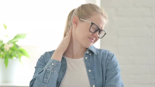 Woman Massaging Stiff Neck Indoors