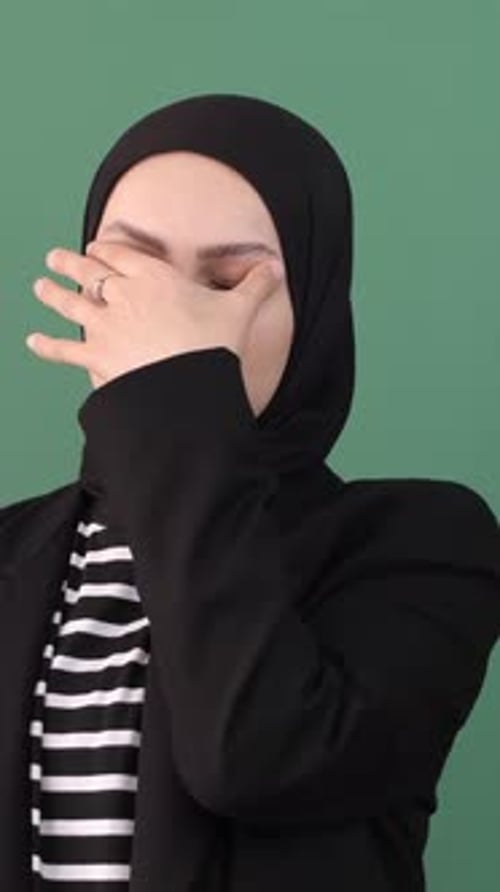 Woman In Hijab Holding Her Head In Her Hands