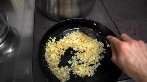 Chef Stirring Sauteed Onions in Pan for Cooking