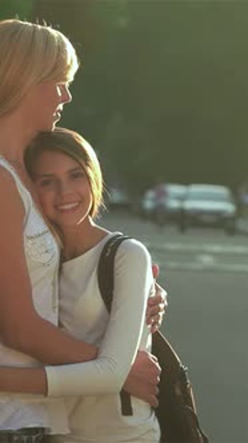 Mother and Daughter Embracing Joyfully on a Sunlit Road