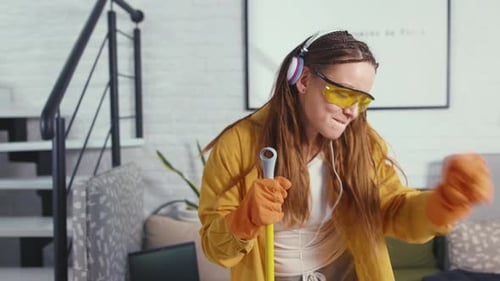 Close Up Cute Young Woman Having Fun During Cleanup Singing and Dancing with Mop Enjoying Music in