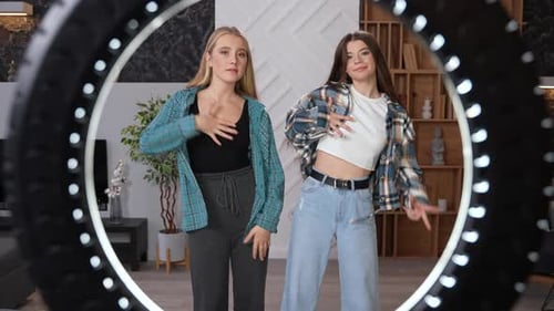 Two Young Women Dancing in Front of Ring Light