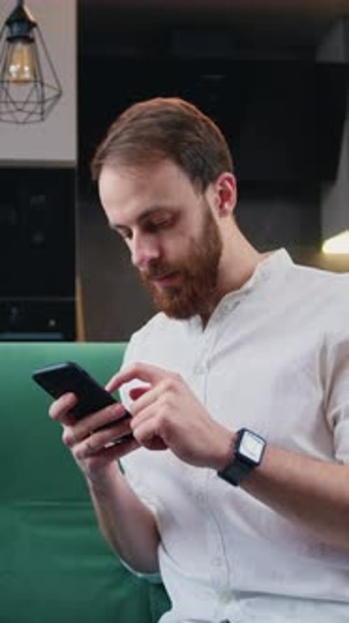Man Using Mobile Phone While Relaxing on Sofa