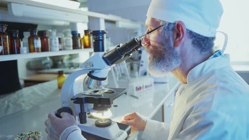 Scientist Analyzing Sample with Microscope in Laboratory