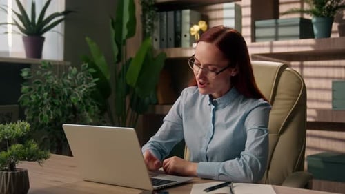 Woman Smiling After Closing Laptop at Work