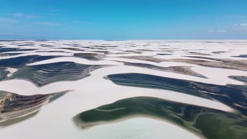 Aerial View of Desert Sand Dunes with Blue Water