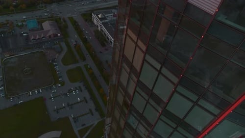 Aerial View of a Modern Glassed Office Skyscraper Exterior with Cityscape Reflection in the Windows
