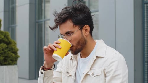 Happy Indian Man Enjoying Drinking Morning Coffee Hot Drink Relaxing Taking a Break in City Street