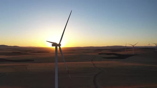 Aerial View Of Wind Power Plants In Wide Field At Sunset