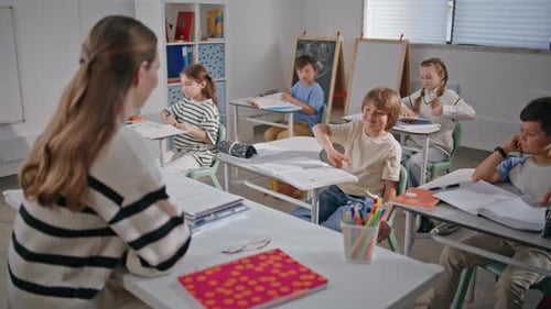 Smiling Teacher Asking Questions to Kids in Elementary School Class Room Closeup