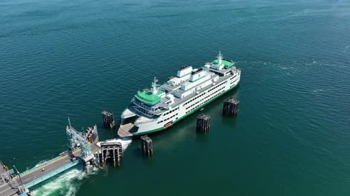 Overhead aerial shot of a ferry leaving the dock and setting sail.