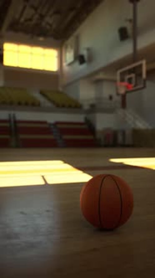Basketball Resting on College Court Floor